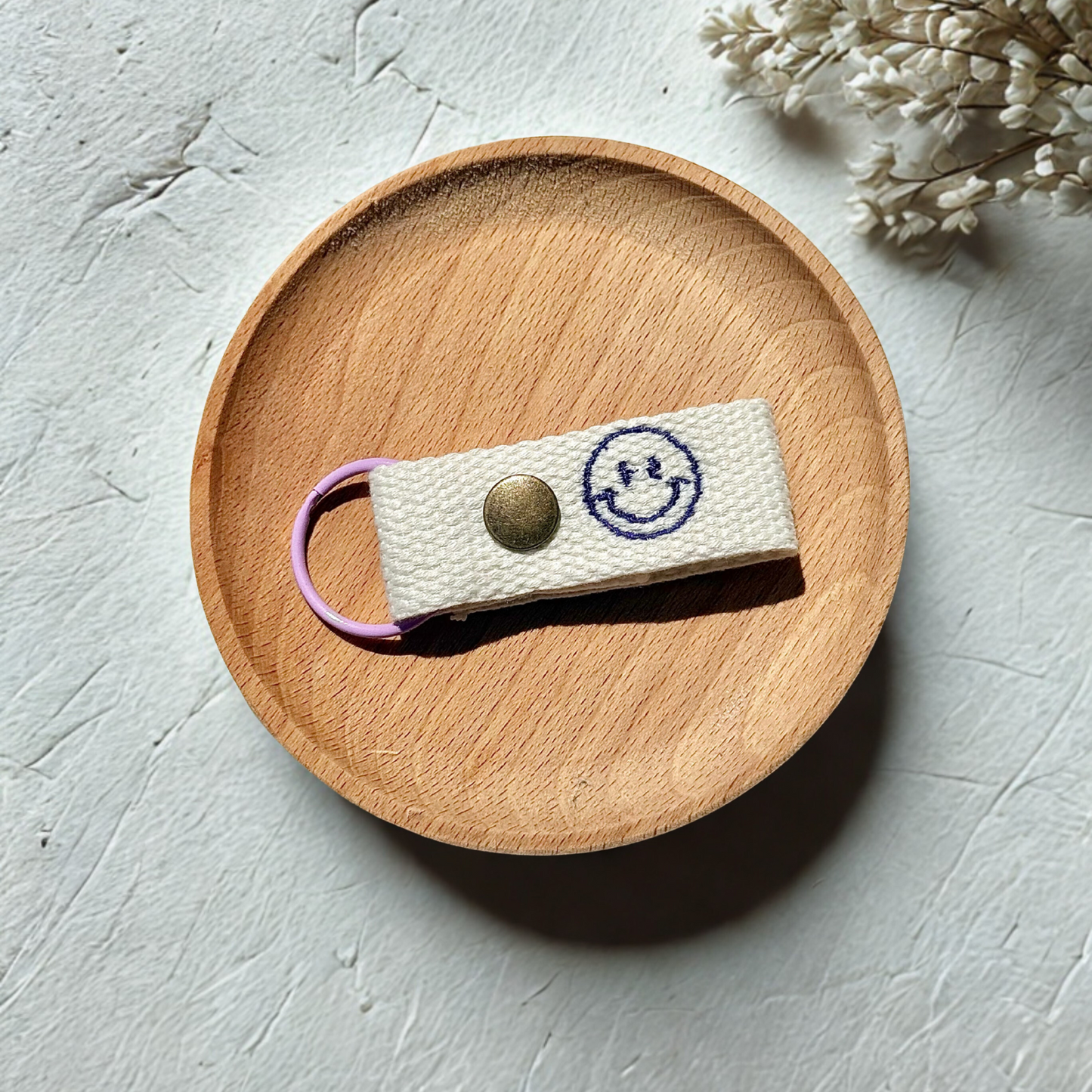 Embroidered name tag with smiley face design